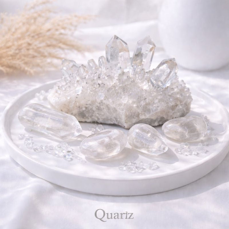 Clear quartz crystals arranged on a white surface in bright natural light, showing their transparent clarity and subtle reflective sparkle