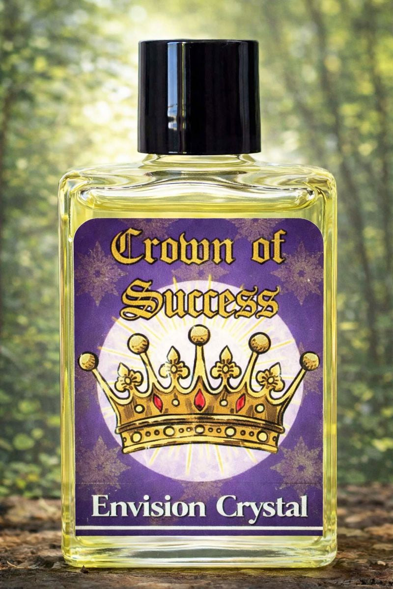 Bottle labeled 'Crown of Success Envision Crystal' with a purple label featuring a gold crown design, against a blurred natural background.